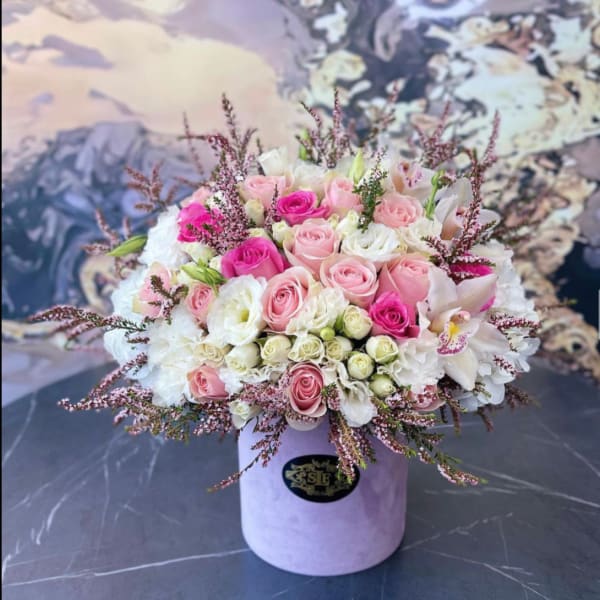 Bouquet of pink and white roses in a lavender hat box
