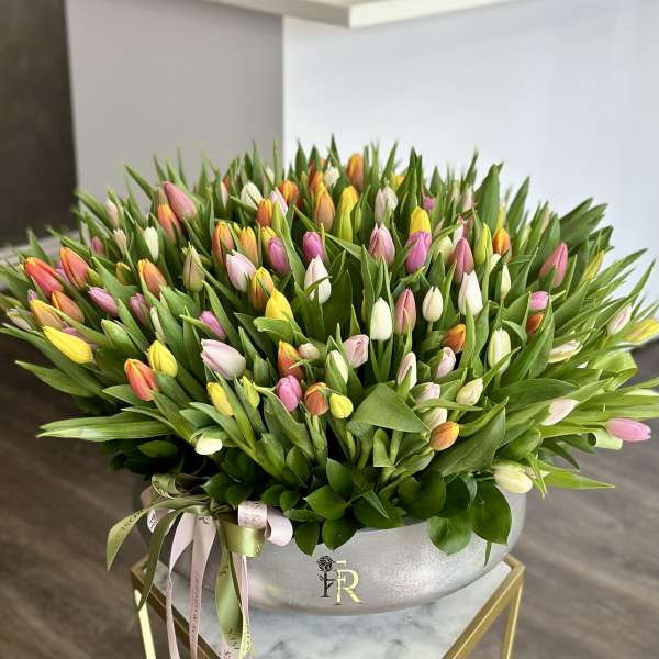 Large bouquet of multicolored tulips in a silver vase