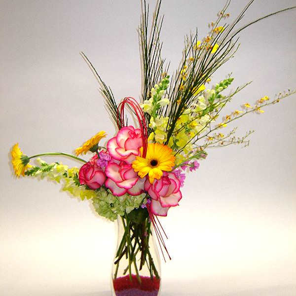 Tall vase arrangement with pink roses and yellow gerbera daisies
