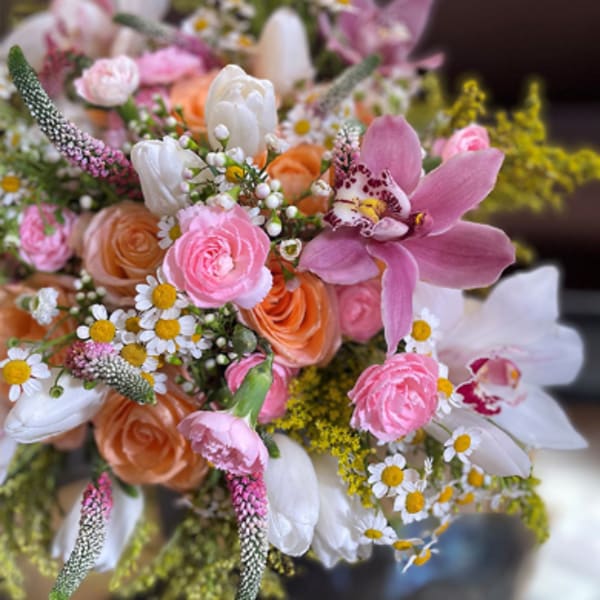 Bouquet of pink, white, and peach flowers with a large pink orchid