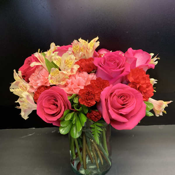Pink roses and carnations in a glass vase
