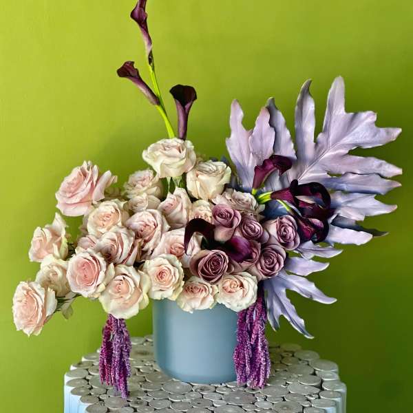 Bouquet of pale pink and lavender roses in a blue vase