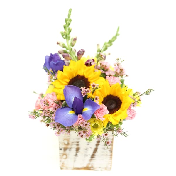 Sunflowers and purple irises in a rustic wooden container