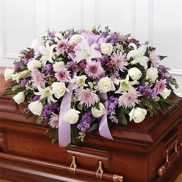 Lavender and white floral spray on a casket