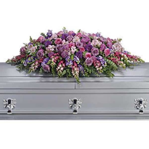 Lavender and pink floral casket spray on a silver casket