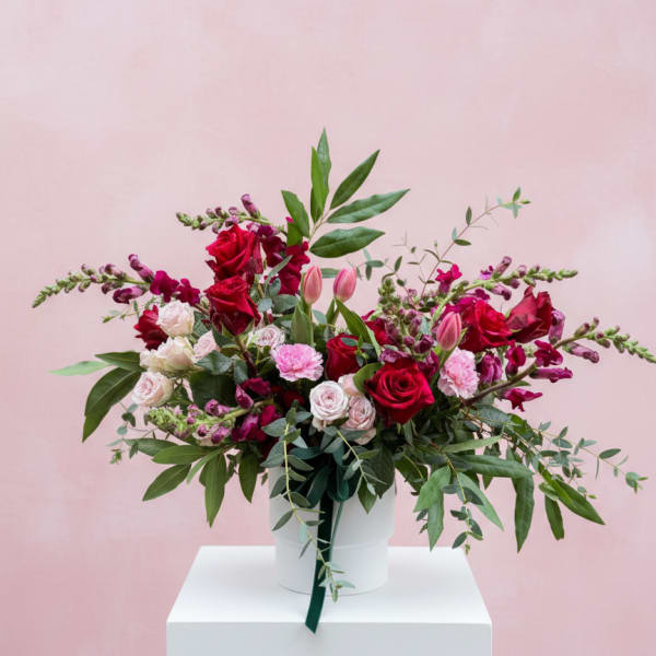 Bouquet of red and pink roses in a white hatbox