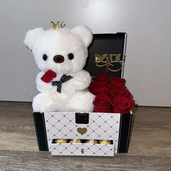 White teddy bear in a gift box with red roses and chocolates