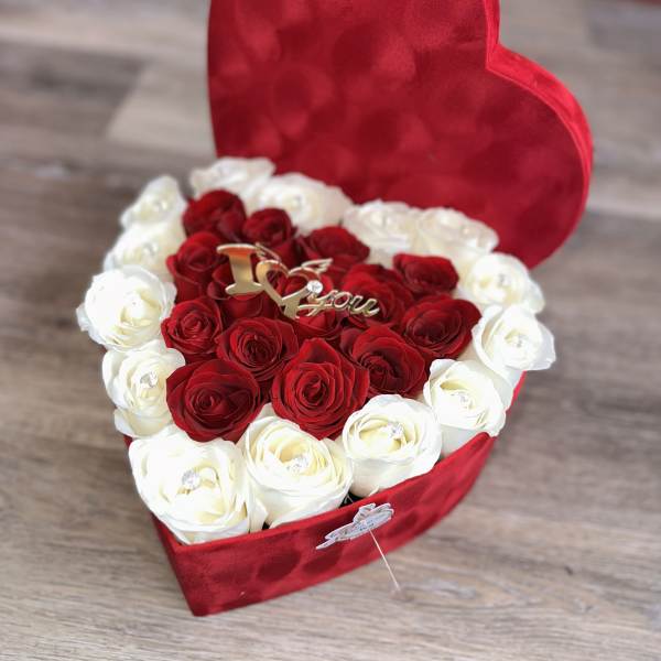 Heart-shaped red box filled with red and white roses