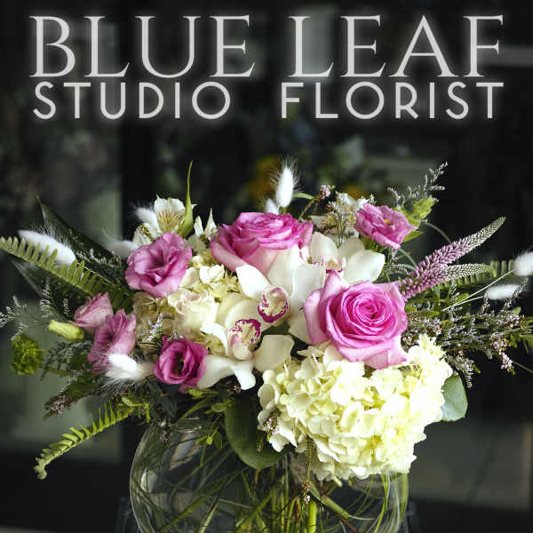 Pink roses and white hydrangeas in a round glass vase