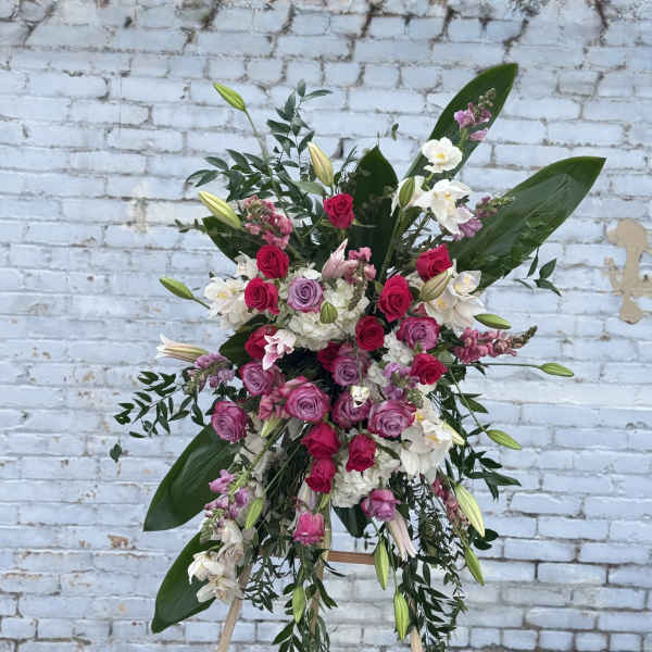Large standing floral spray with pink and white roses on an easel