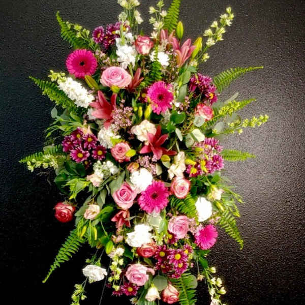 Tall floral spray with pink roses, gerbera daisies, lilies, and white blooms