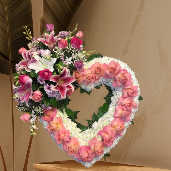 Heart-shaped floral wreath with pink roses and lilies