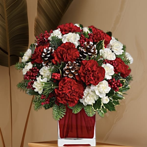 Red and white floral arrangement in a clear square vase