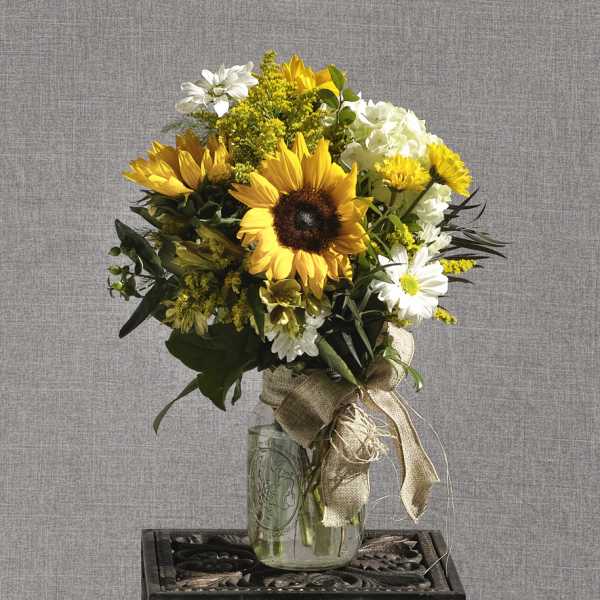 Sunflower bouquet in a glass jar with a burlap ribbon