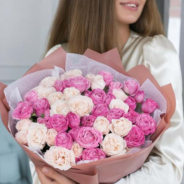 Bouquet of pink and blush roses wrapped in pink paper
