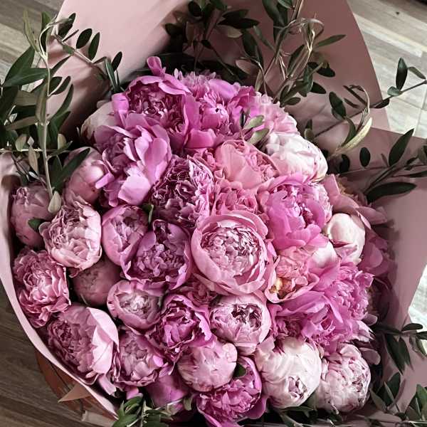 Pink peony bouquet wrapped in blush paper with greenery