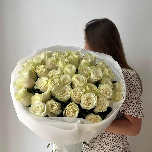 Large bouquet of cream roses wrapped in white paper