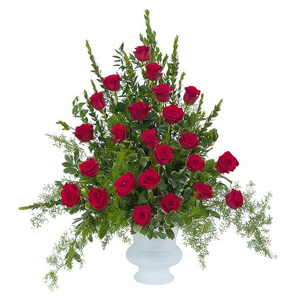 Tall fan-shaped arrangement of red roses in a white pedestal vase