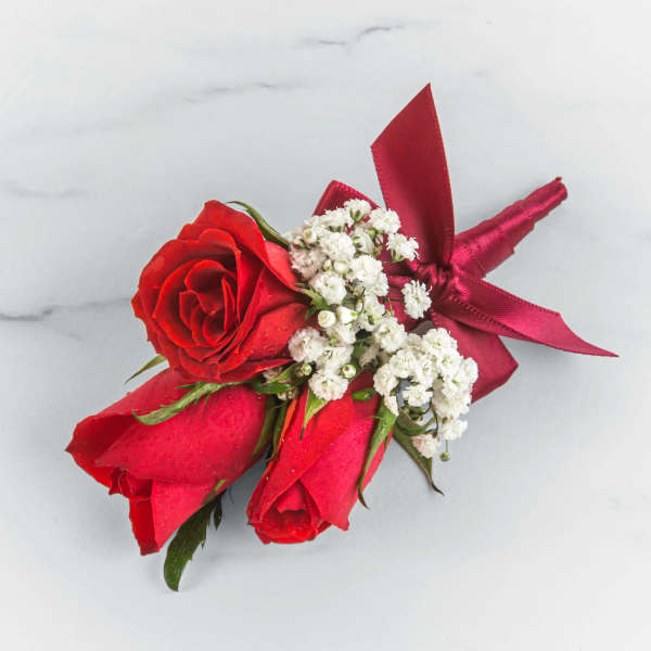 Three red roses with white baby's breath and a red ribbon boutonniere