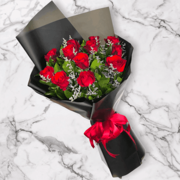 Bouquet of red roses wrapped in black paper with a red ribbon