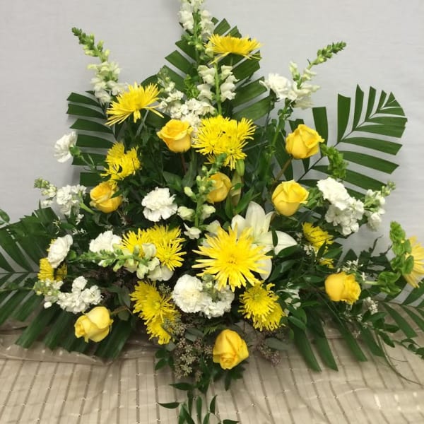 Yellow roses and white flowers in a large standing arrangement