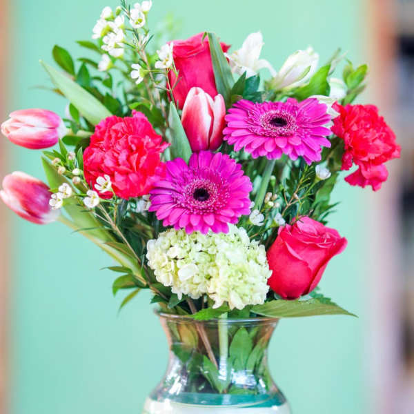 Pink and white mixed bouquet in a striped glass vase
