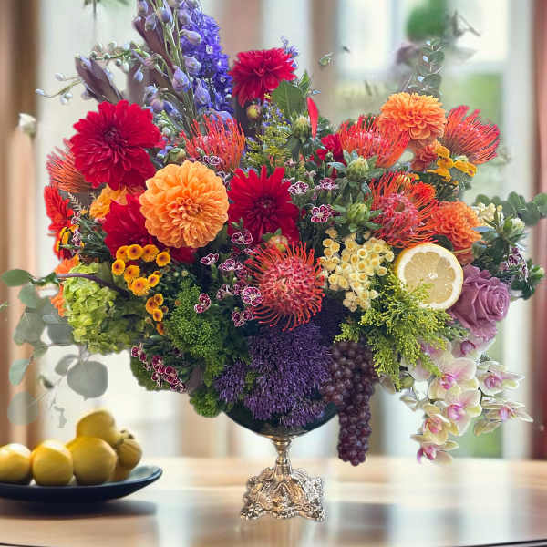 Colorful mixed flower arrangement in a silver pedestal vase