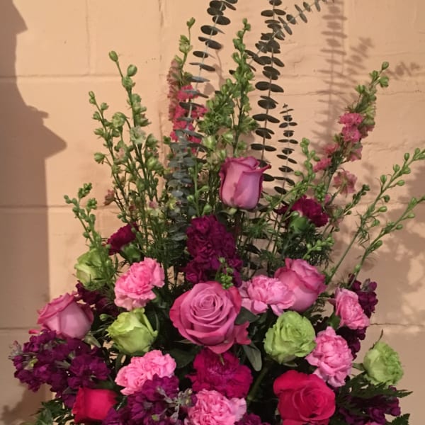 Pink and purple floral arrangement in a white vase