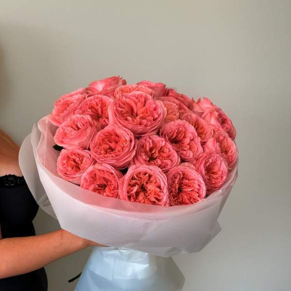 Bouquet of bright pink roses wrapped in pale paper