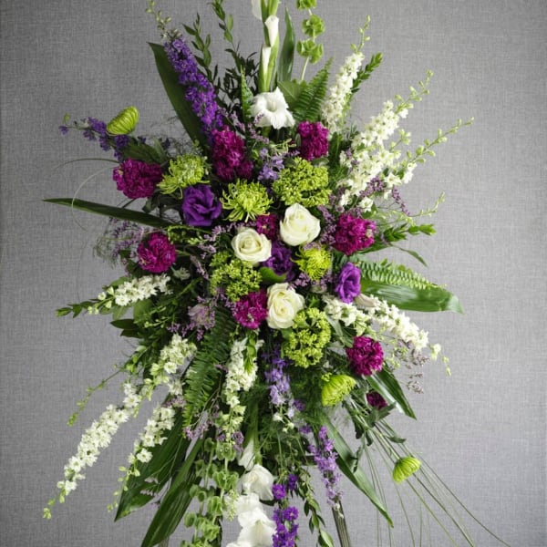 Tall standing floral spray with purple, white, and green flowers