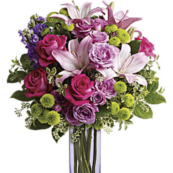 Bouquet of pink and purple flowers in a tall glass vase