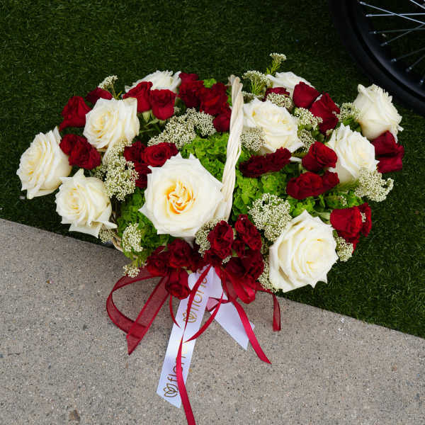 Heart-shaped bouquet of red and white roses with ribbon
