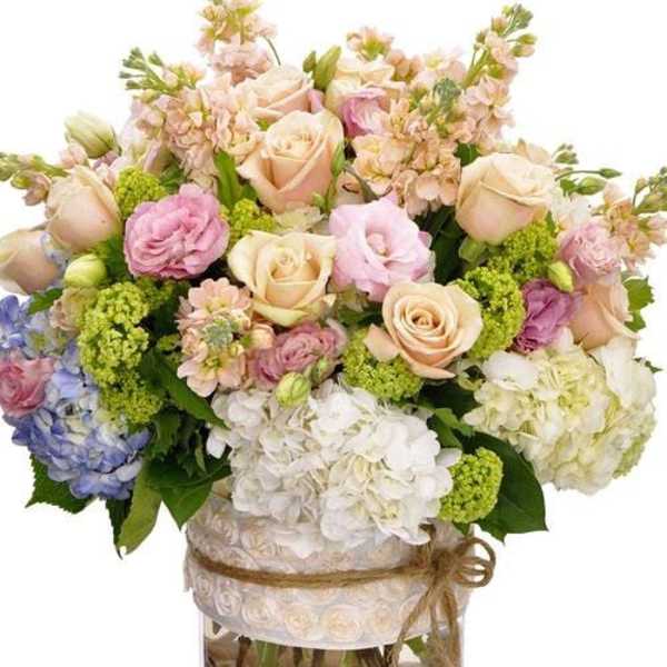 Pastel bouquet of roses and hydrangeas in a clear vase
