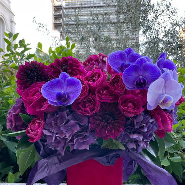 Bouquet of purple and magenta flowers in a red box