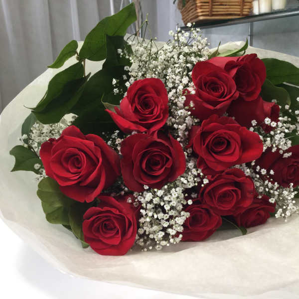 Bouquet of red roses with baby's breath wrapped in white paper