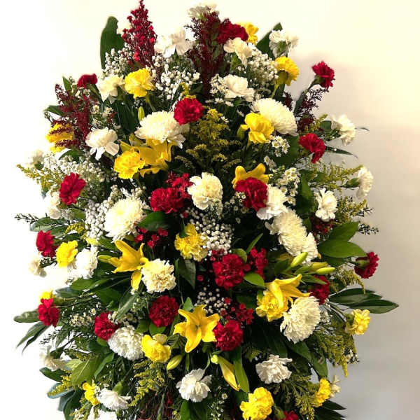 Large standing floral spray with red, white, and yellow flowers