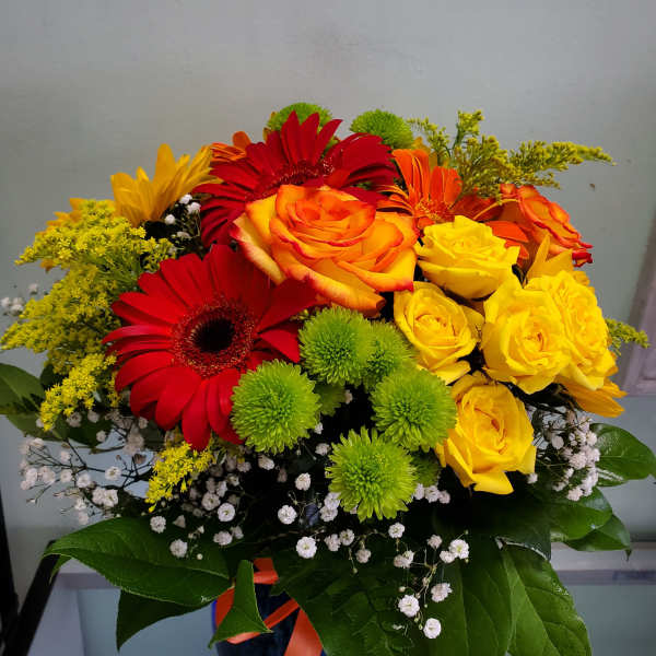 Bouquet of red, orange, and yellow flowers in a dark vase