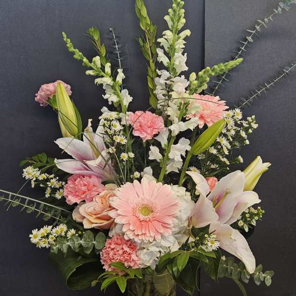 Pink and white mixed flower arrangement in a glass vase