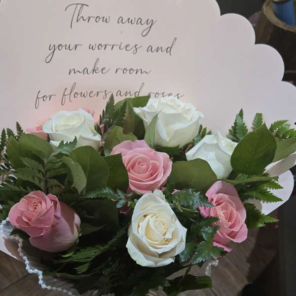 Bouquet of pink and white roses with a scalloped card