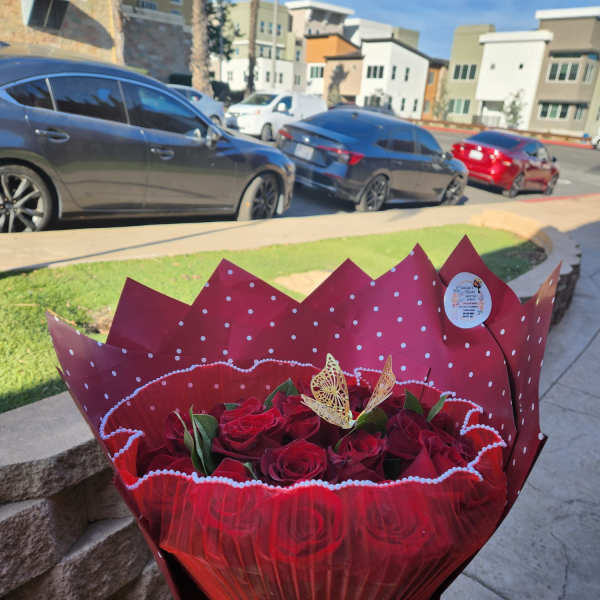 Bouquet of red roses wrapped in red paper with a ribbon