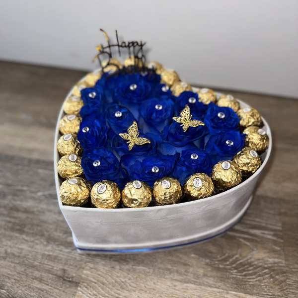 Heart-shaped box of blue roses with gold-wrapped chocolates