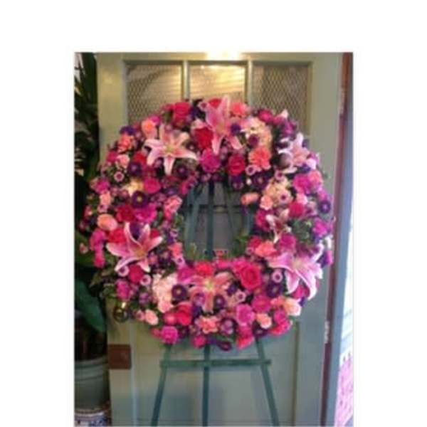 Large pink and purple floral wreath on an easel