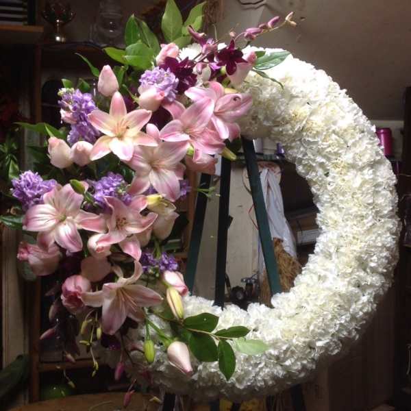 Large crescent floral wreath with pink lilies and white blooms