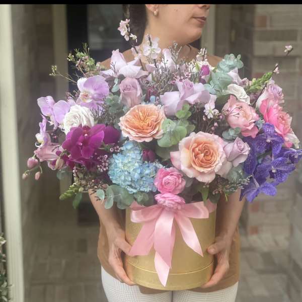 Large pastel bouquet in a gold box with a pink ribbon