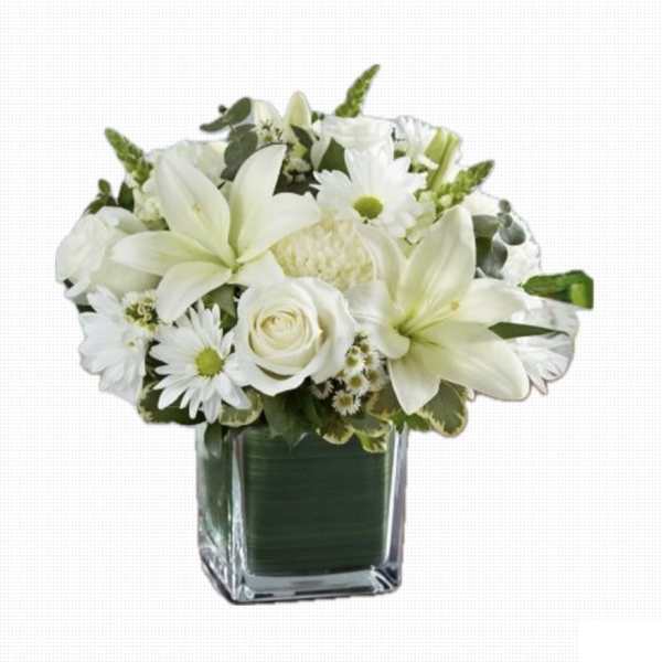 White lilies, roses, and daisies arranged in a square glass vase lined with green inside