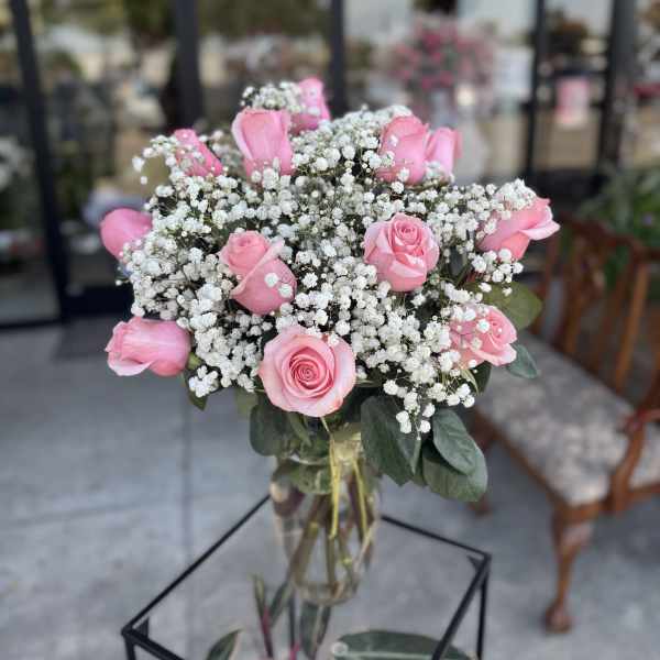 Pink roses and baby's breath in a clear glass vase