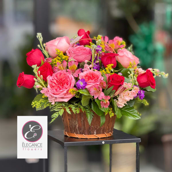 Pink and red rose arrangement in a wooden basket