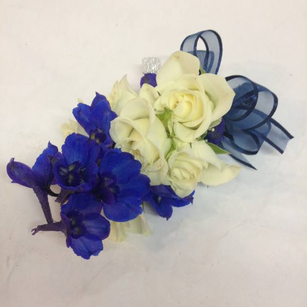 Small bouquet of white roses and blue flowers tied with ribbon