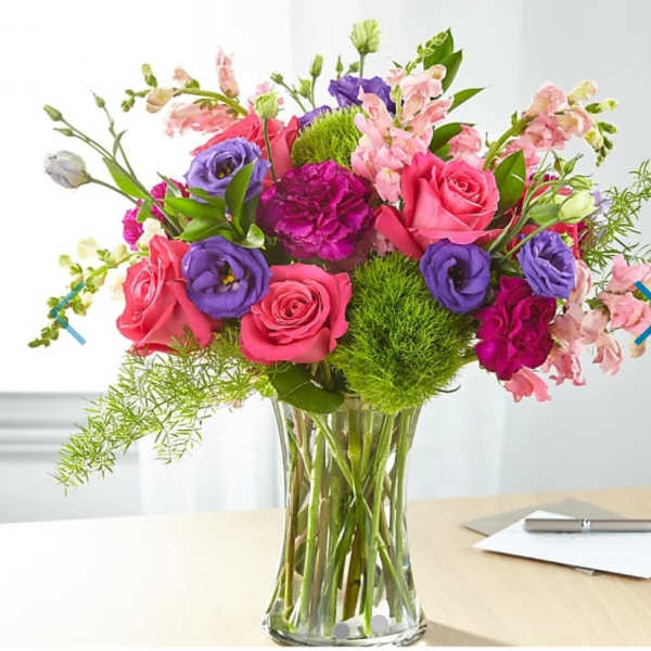 Bouquet of pink and purple flowers in a clear glass vase