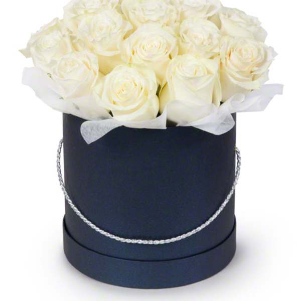White roses arranged in a black round hat box